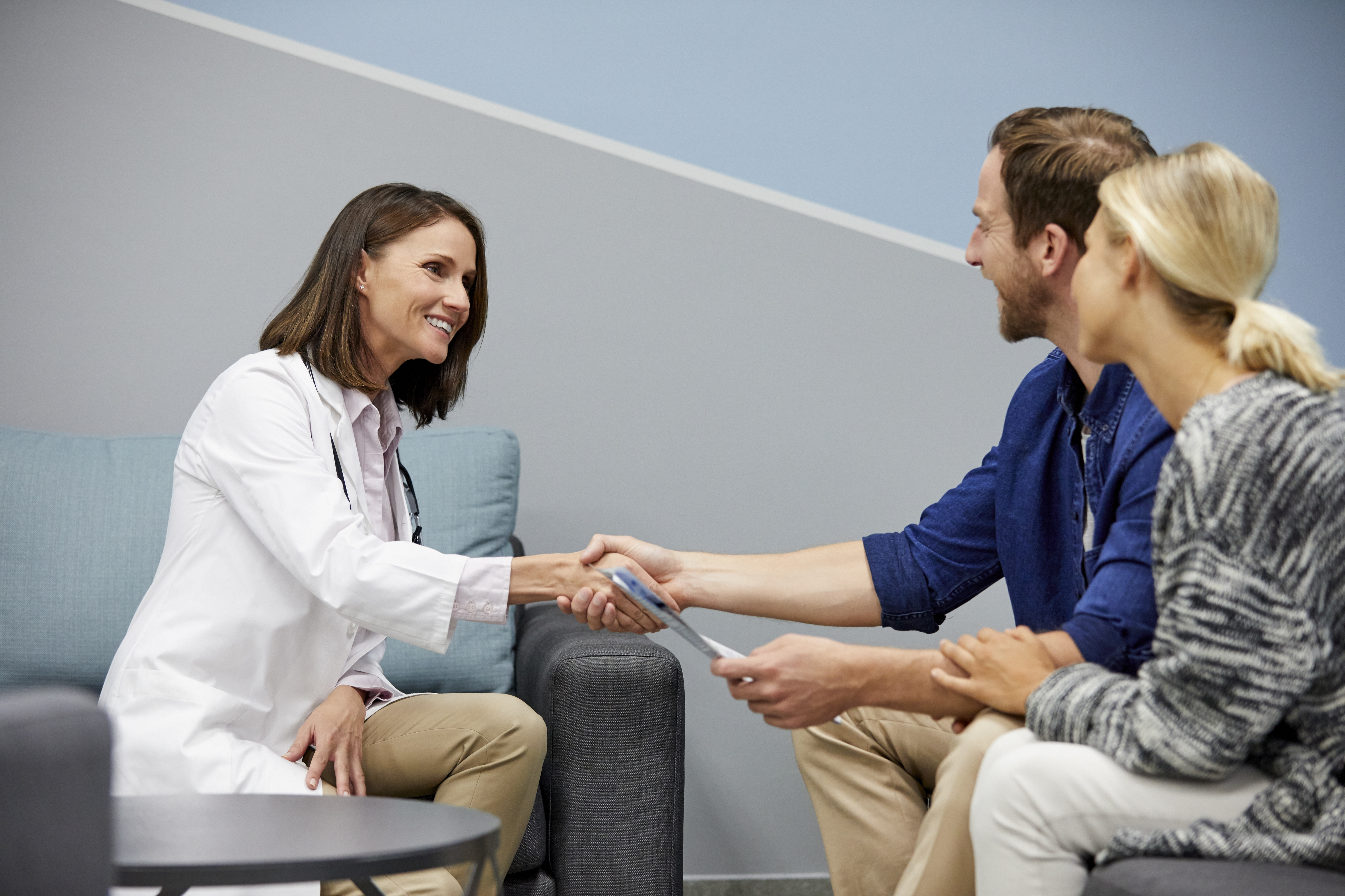 Health care worker talking to young adult couple